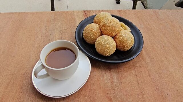 coffee and cookies,Sesame balls or Onde onde or Jiandui or Kue moci or Kuih bom,a type of Chinese pastry,made from glutinous rice,coated with sesame seeds,filled with a filling usually beans,served wi