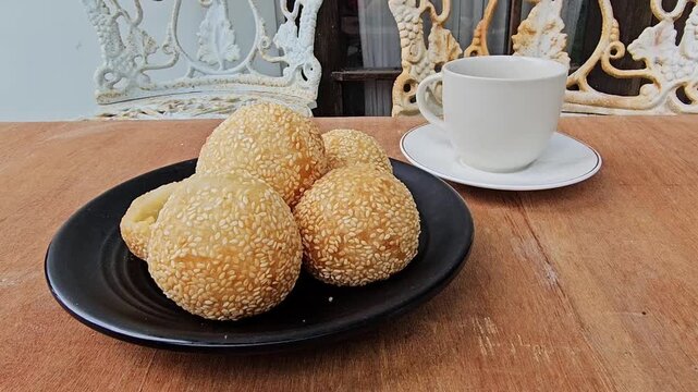 coffee and cookies,Sesame balls or Onde onde or Jiandui or Kue moci or Kuih bom,a type of Chinese pastry,made from glutinous rice,coated with sesame seeds,filled with a filling usually beans,served wi