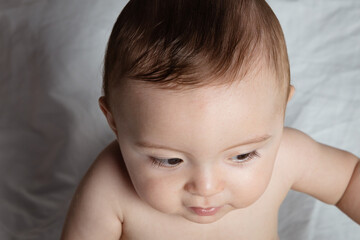 Close-up of a charming toddler on white fabric