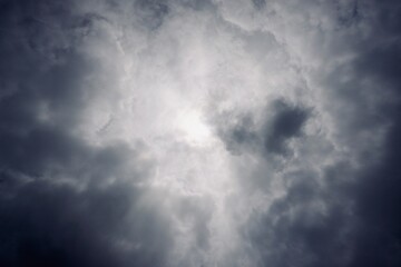Dark dramatic cloud cover with light piercing through, symbolizing raw atmospheric energy and change.