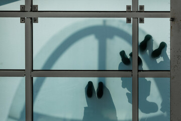 Low-angle view silhouetted people standing on semiopaque mint green  observation deck surface. Dark...