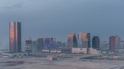 Fototapeta premium Buildings on Al Reem island in Abu Dhabi night to day timelapse from above.
