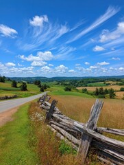 Scenic Countryside Landscape Featuring Rolling Hills, Rustic Fence, and Blue Sky on a Sunny Day in Rural Area