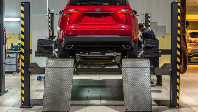 Car on stand with sensors on wheels for wheels alignment camber check in workshop of Service station timelapse.