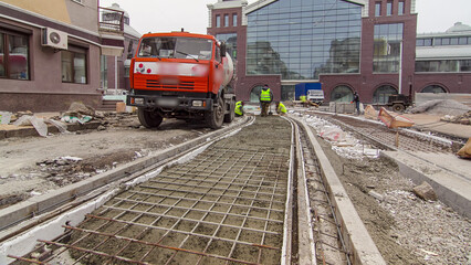 Pouring ready-mixed concrete after placing steel reinforcement to make the road by concrete mixer...