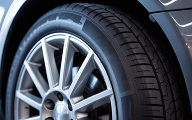 Macro shot of a car alloy wheel and tire tread, clean metallic surface