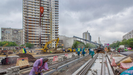 Gray construction telescopic crane unloading tram rails from truck timelapse.