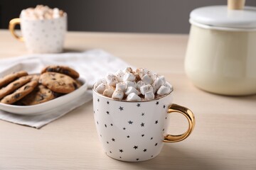 Cup of hot drink with marshmallows on wooden table,