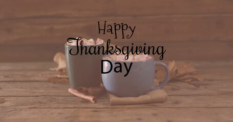 Image of happy thanksgiving day text over mugs with hot chocolate on wooden background