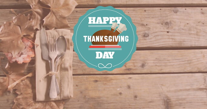Fototapeta Image of happy thanksgiving day text over cutlery on wooden background