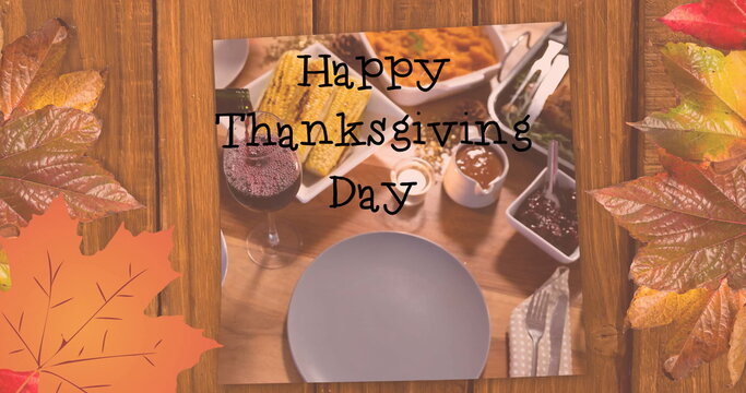 Fototapeta Image of happy thanksgiving day text over dinner and autumn leaves background
