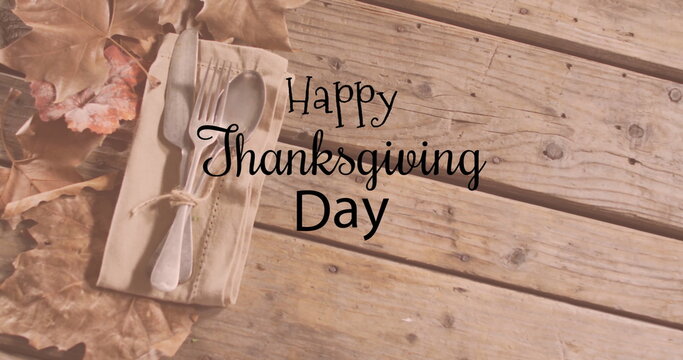 Fototapeta Image of happy thanksgiving day text over cutlery on wooden background
