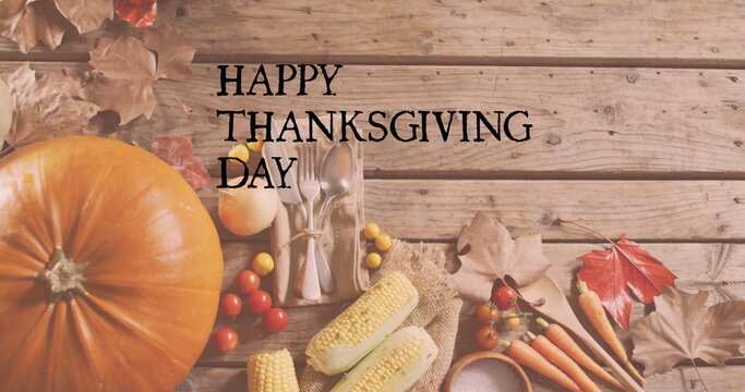 Fototapeta Image of happy thanksgiving day text over autumn leaves and produce on wooden background