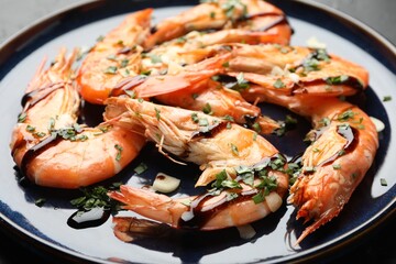 Tasty grilled shrimps with sauce on black table, closeup. Delicious seafood dish