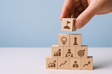 Building Blocks of Success: Hand Placing Goal Icon on Pyramid of Strategy and Achievement
