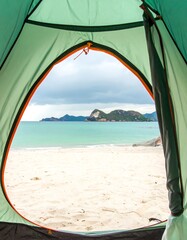 View from a tent on a beach with distant islands