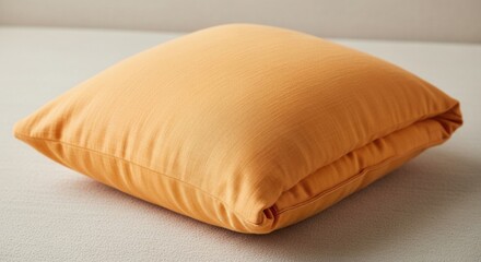 Fototapeta premium Soft orange pillow cushion with fabric texture on neutral background for home decor