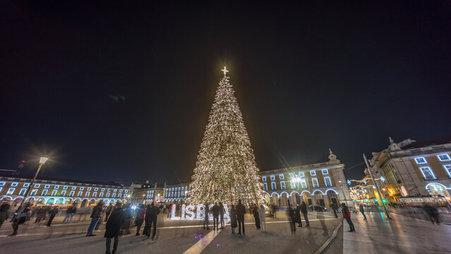 Commerce Square in Lisbon illuminated at Christmas hyperlapse, with a towering tree and crowds celebrating at night. Portugal