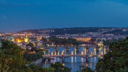 Fototapeta premium Scenic view of bridges on the Vltava river day to night timelapse and of the historical center of Prague: buildings