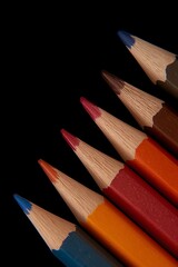 Obraz premium Vibrant close up of sharpened colored pencils aligned on a dark black background, creative art supplies composition for design, drawing, school, education, creativity and backdrop use