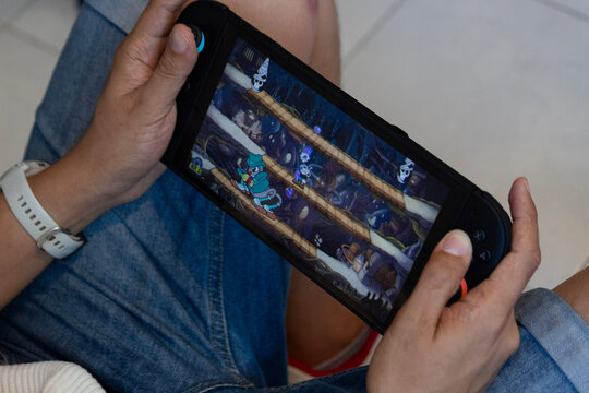 a male hands playing cuphead video game into a new nintendo switch 2 video game system