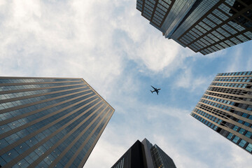 Airplane Flying Overhead Between Skyscrapers