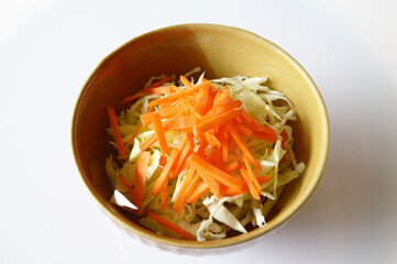 fresh cabbage salad with carrot and onion on white plate