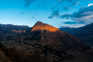 Obraz premium Golden sunset over the Sacred Valley in Cusco, Peru, with light on the mountain peak, terraces, and dramatic Andean landscapes.