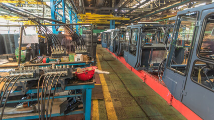 Conveyor assembly stage the body of tractor at big industrial factory timelapse