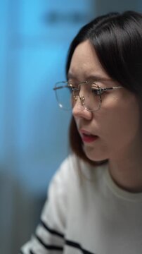 A female software developer analyzes a complex algorithm, debugging lines of code on her monitor. She is engaged in a deep work session in a quiet tech office at night.