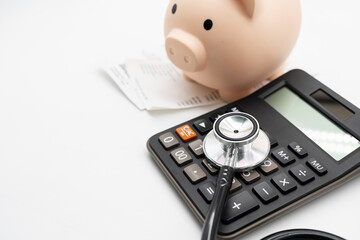 Piggy bank, calculator, and stethoscope with medical bills, symbolizing healthcare expenses, medical cost management, and financial planning. Health insurance, hospital billing, and medical cost.