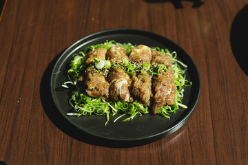 Sizzling Korean BBQ pork belly (samgyeopsal) on tabletop charcoal grill with rising smoke and traditional banchan side dishes, close-up shot in cozy restaurant setting with copy space.