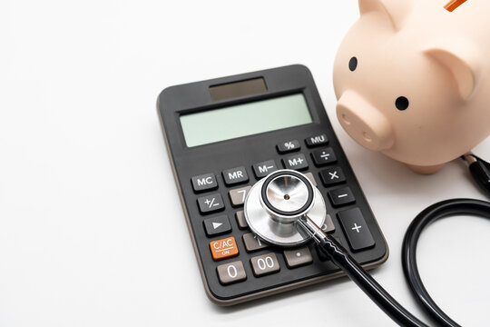 Calculator, Piggy bank and stethoscope on white background health medicine theme with copy space. Health care costs, medical cost management or medical insurance. - Powered by Adobe