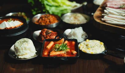Grilled Korean beef short ribs (galbi) with caramelized edges on hot grill, served with lettuce wraps and kimchi, authentic Korean barbecue dining experience, overhead view.