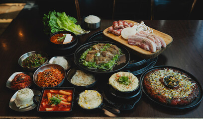 Grilled Korean beef short ribs (galbi) with caramelized edges on hot grill, served with lettuce wraps and kimchi, authentic Korean barbecue dining experience, overhead view.