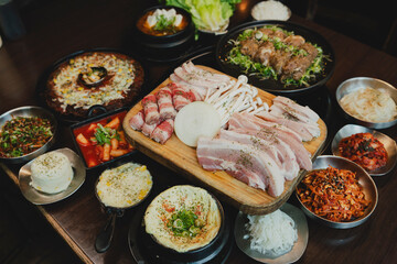 Grilled Korean beef short ribs (galbi) with caramelized edges on hot grill, served with lettuce wraps and kimchi, authentic Korean barbecue dining experience, overhead view.