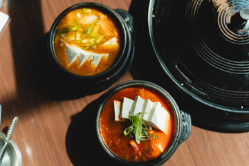 Grilled Korean beef short ribs (galbi) with caramelized edges on hot grill, served with lettuce wraps and kimchi, authentic Korean barbecue dining experience, overhead view.