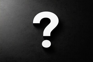 large white question mark casting shadow on textured black surface conveying mystery and inquiry