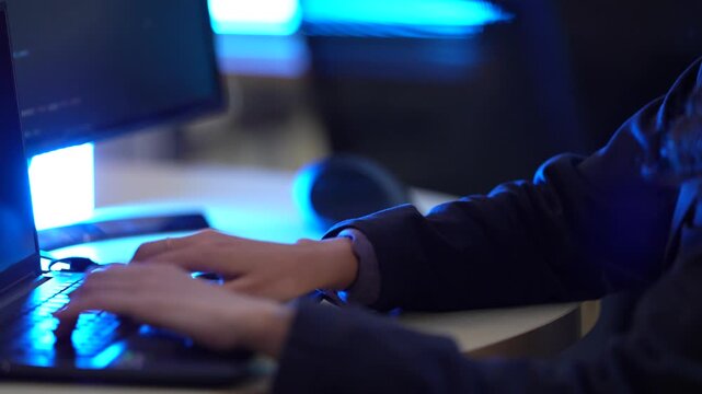 A software developer's hands type rapidly on a laptop keyboard, writing source code in an IDE. This illustrates the fast-paced nature of data input in a tech environment.