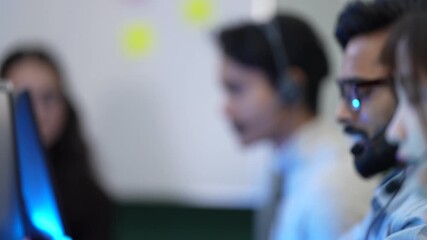 A diverse team of customer support agents works in a modern call center office. The operators are busy assisting clients over the phone with their questions and technical problems. - Powered by Adobe