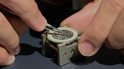 close-up watchmaker's hands making watch timepiece