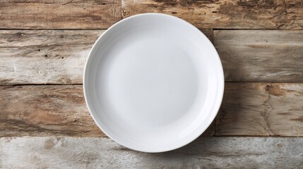 White ceramic plate with smooth rim on aged wooden planks. Top view