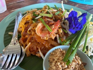Pad Thai with seafood in a green plate on the table