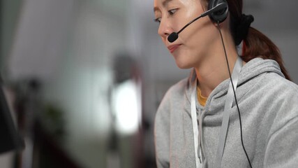A female customer support agent assists a client with a technical issue. She wears a headset and types on a keyboard in a professional call center or modern office. - Powered by Adobe