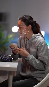 A female programmer concentrates on her computer screen, with code projected onto her face and glasses. This image represents a deep focus on software development and data.