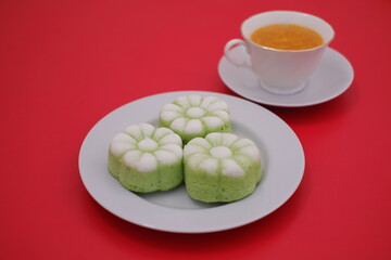 Delicious Flower-Shaped Cakes and Tea on a Red Background
