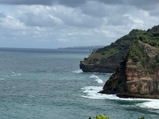 Coastal Vista: A stunning coastal scene unfolds with dramatic cliffs meeting the vast ocean under a cloudy sky, evoking a sense of serenity and natural beauty.