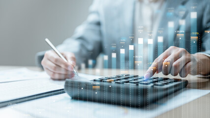 Businessman using calculator with financial graphs overlay. Perfect for concepts of finance, accounting, investment, analysis, economy, business growth, tax, profit, management
