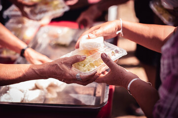 Receiving food for the poor from volunteers, concept of feeding, Homeless people receive delicious charity food from volunteers: concept of helping by donating food
