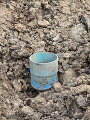 blue plastic tube with dirty ground on the ground